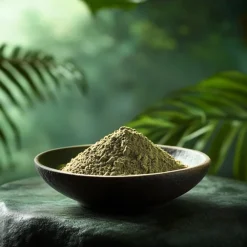 A bowl of green Mitragyna Hirsuta on a flat rock.