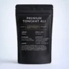 A Tongkat Ali Physta matte black stand-up pouch labeled “Premium Tongkat Ali” is shown against a soft light gray background. The packaging features white and gold text with product details including origin, shelf life, storage, content, and usage instructions.